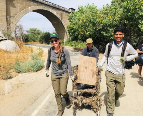 Two volunteers and RLC staff member Amy Tims collect trash on the Santa Ana River Trail